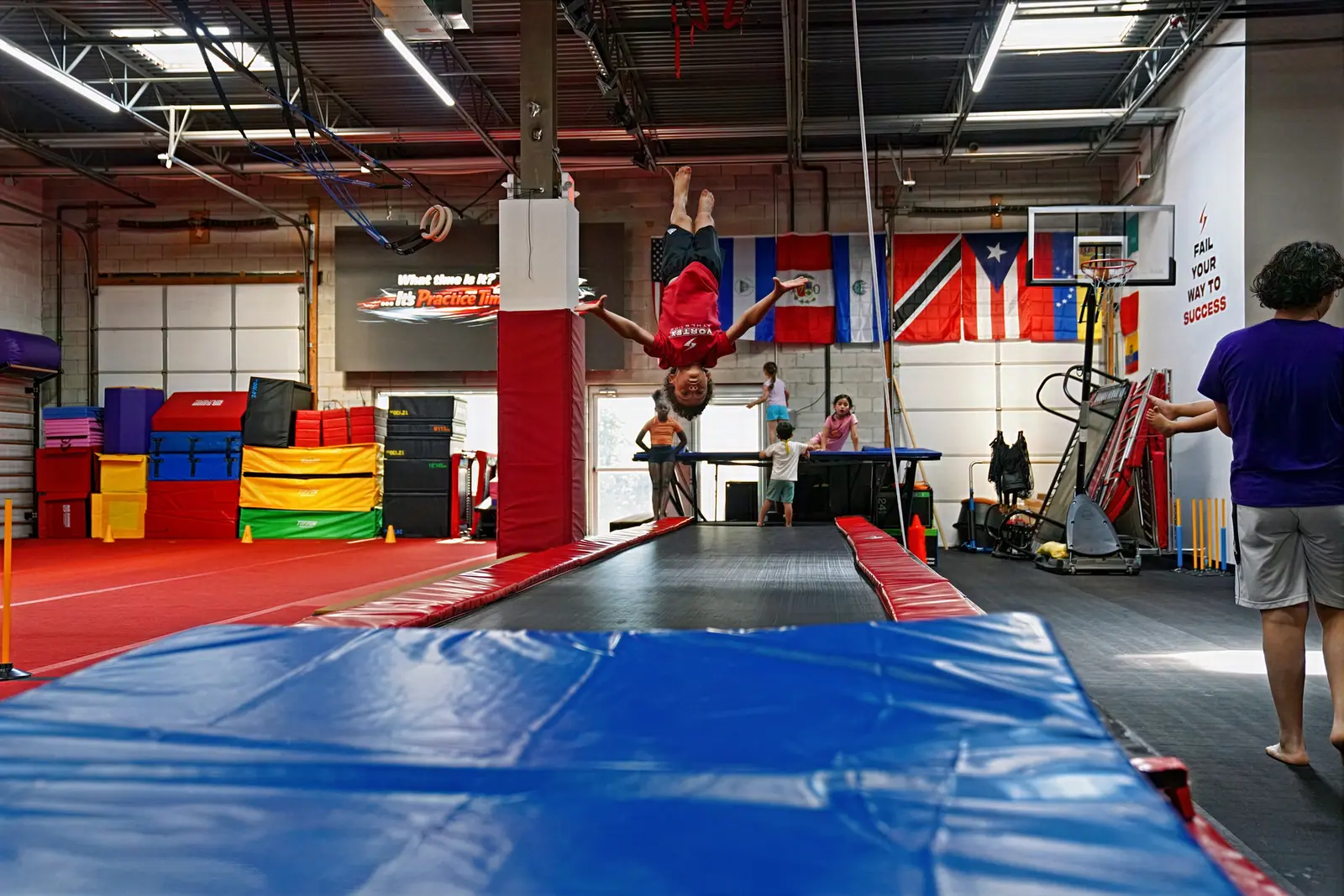A Vortex athlete performing a tumbling skill on the power tumbling track