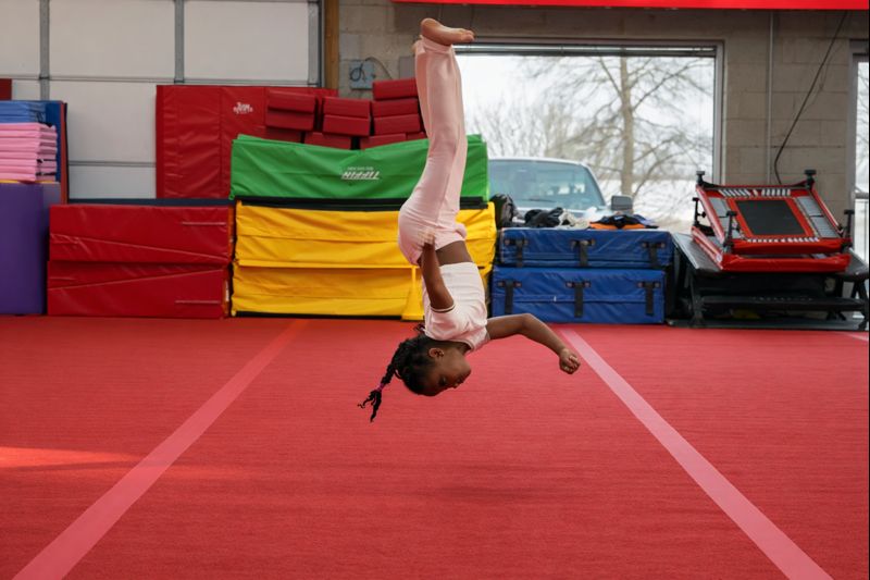 Young athlete performing a flip during tumbling training at Vortex